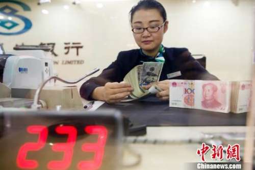 资料图:银行工作人员正在清点货币。 张云 摄