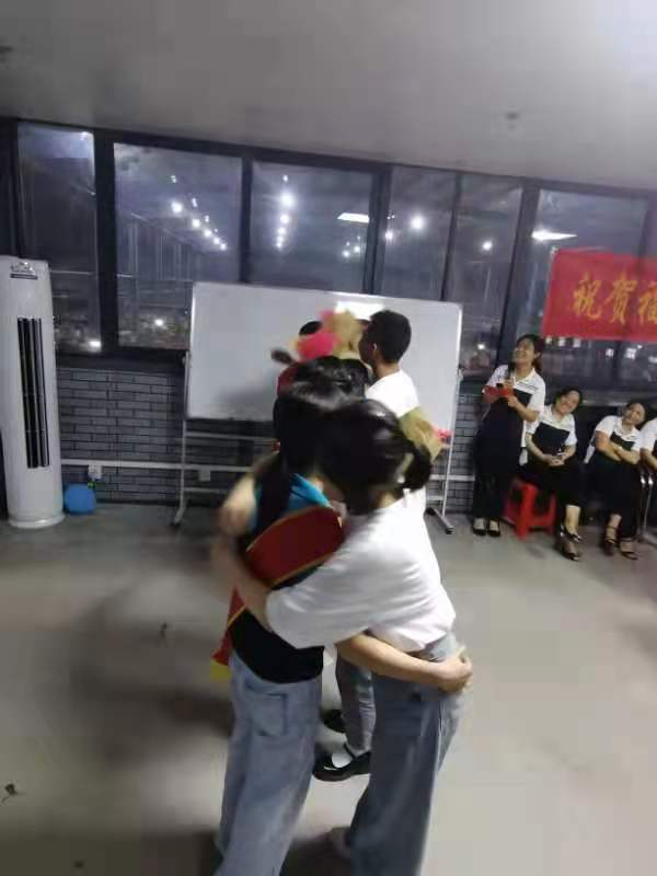 获得奖学金的学生现场向家长献花、拥抱家长